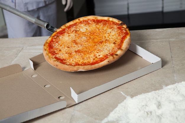 Foto panadero masculino preparando pizza para la entrega