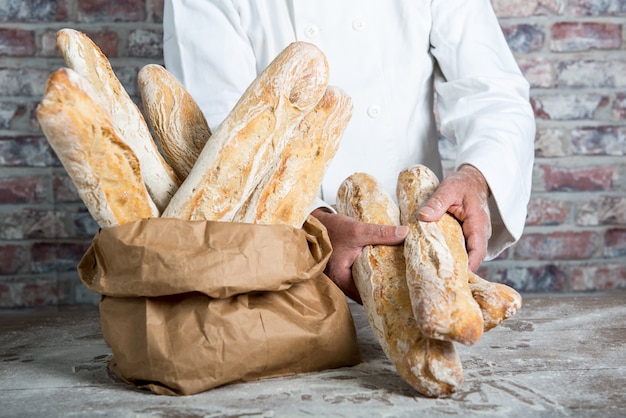 Foto panadero con pan tradicional baguettes francesas