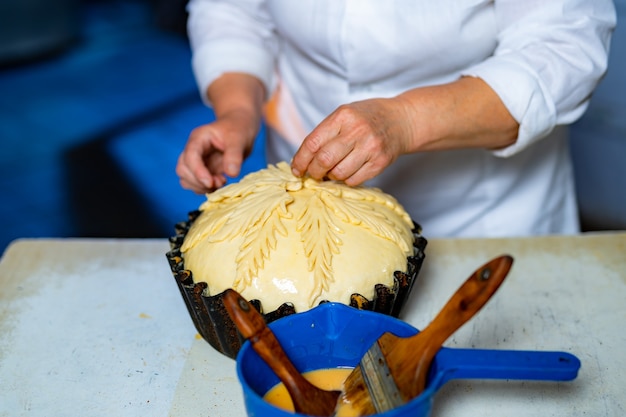 Panadero profesional preparando pan dulce. Decoración de pastelería en línea de producción.