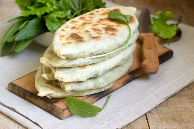 El panadero que hace un plato tradicional de armenios con sombreros Artsakh Zhingyalov es un tipo de pan plano relleno de hierbas.