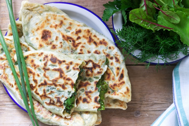 El panadero que hace un plato tradicional de armenios con sombreros Artsakh Zhingyalov es un tipo de pan plano relleno de hierbas.