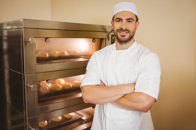 Panadero sonriendo a la cámara al lado del horno