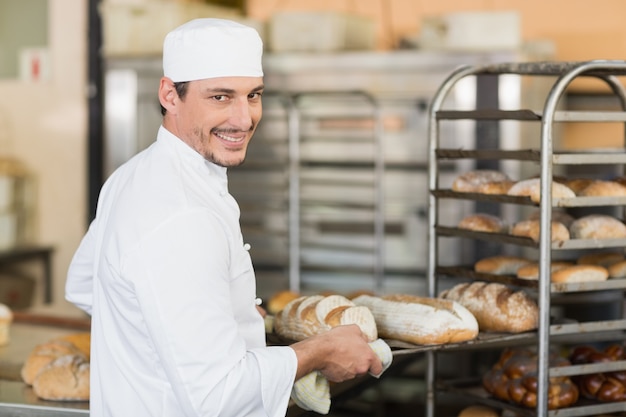Foto panadero sonriente, tenencia, bandeja, de, pan