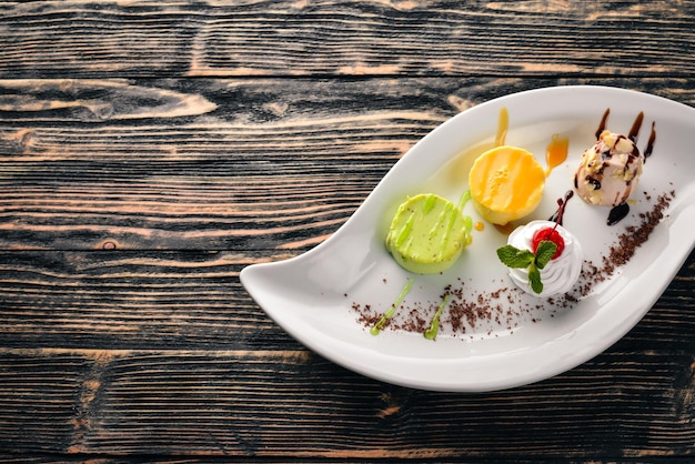 Panakota con sabor a pistacho, naranja, chocolate. Sobre un fondo de madera. Espacio libre para su texto. Vista superior.