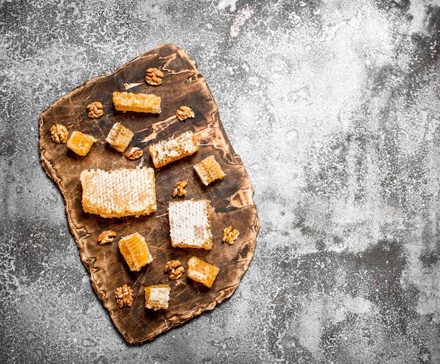 Panal fresco con nueces. Sobre mesa rústica.