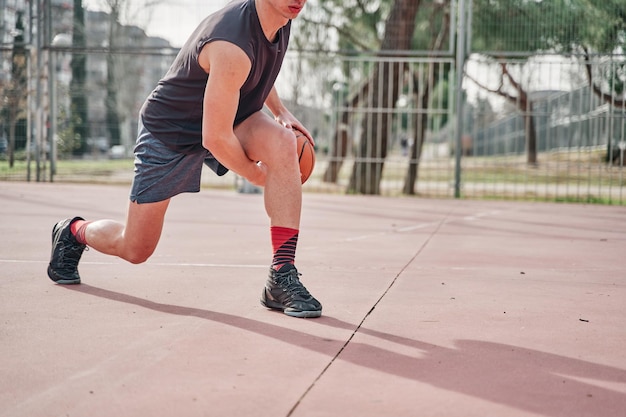 Pancarta de un deportista con una pelota de baloncesto en una cancha de barrio practicando regates