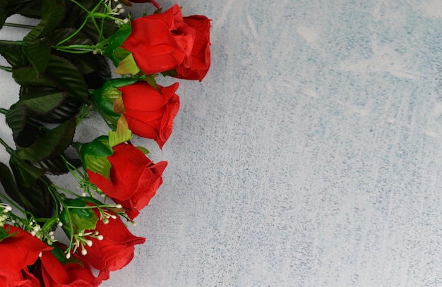 Pancarta con flores rosas rojas y perlas sobre un fondo gris en las celebraciones del día de San Valentín el 8 de marzo