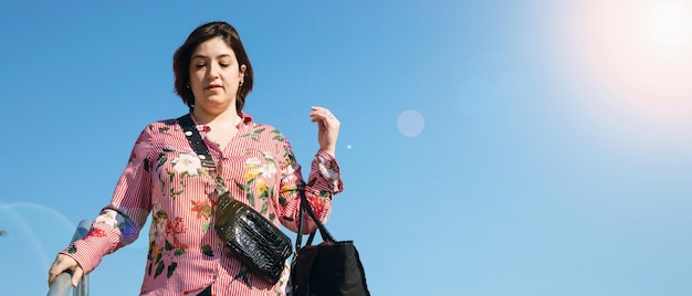 Pancarta de una joven mujer caucásica latina de talla grande al aire libre bajando las escaleras después de ir de compras