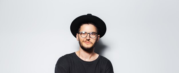 Pancarta panorámica retrato de un joven confiado con sombrero negro sobre blanco