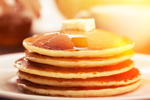 Panckes con mantequilla y almíbar con café de fondo