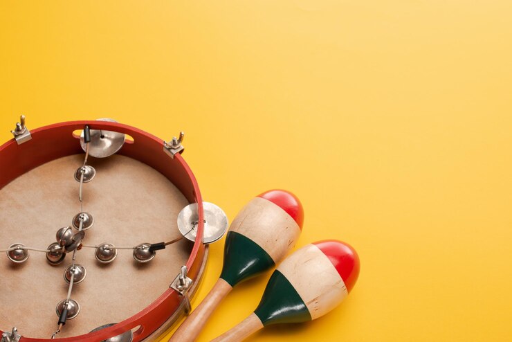 Foto pandeiro perto de maracas de madeira coloridas em fundo amarelo