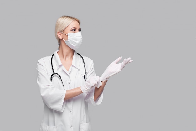 Pandemie des Coronavirus. Ärztin in weißer medizinischer Gesichtsmaske mit Stethoskop. Konzept der Covd-19-Quarantäne.