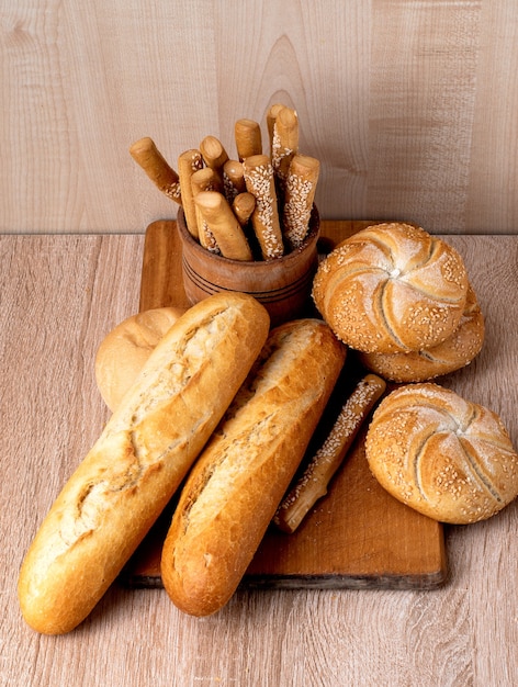 Ð¡pane crujiente con bollos. Baguettes francesas. Pan crujiente fresco. Fondo de pan. Raza diferente sobre fondo de madera.