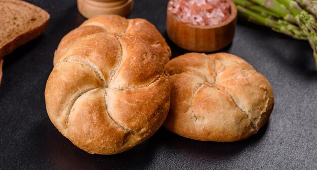 Panecillos redondos crujientes conocidos como Kaiser o rollos de Viena en una tabla para cortar