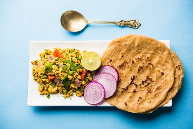 Paneer Bhurji, mild gewürztes Hüttenkäse-Rührei und serviert mit Roti oder Laccha Paratha, selektiver Fokus