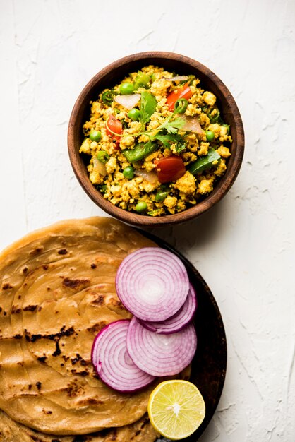 Paneer Bhurji, revuelto de requesón ligeramente condimentado y servido con roti o laccha paratha, enfoque selectivo