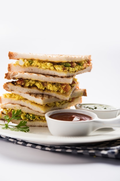 Paneer Bhurji Sandwich ist ein leckeres Gericht auf Paneer-Basis mit Hüttenkäse. serviert mit frischem Tomatenketchup und grünem Minz-Chutney. selektiver Fokus