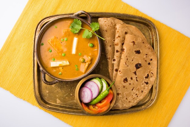 Paneer Butter Masala es una famosa receta de comida india hecha con requesón, servida con pan plano también conocido como roti o chapati. enfoque selectivo