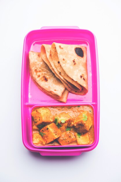 Paneer Butter Masala con Roti en lonchera o tiffin, enfoque selectivo