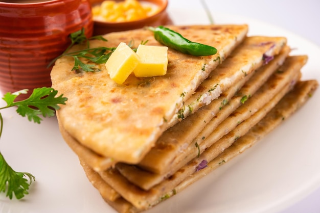 Paneer paratha é um pão achatado popular do norte da Índia, feito com massa de farinha de trigo integral e recheado com paneer ralado picante e saboroso