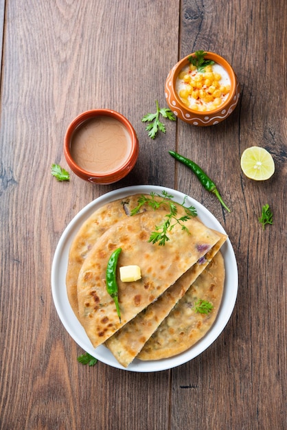 Paneer paratha es un popular pan plano del norte de la India hecho con masa de harina de trigo integral y relleno con paneer sabroso, condimentado y rallado.