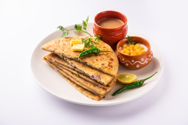 Paneer paratha es un popular pan plano del norte de la India hecho con masa de harina de trigo integral y relleno con paneer sabroso, condimentado y rallado.