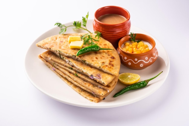 Paneer paratha es un popular pan plano del norte de la India hecho con masa de harina de trigo integral y relleno con paneer sabroso, condimentado y rallado.