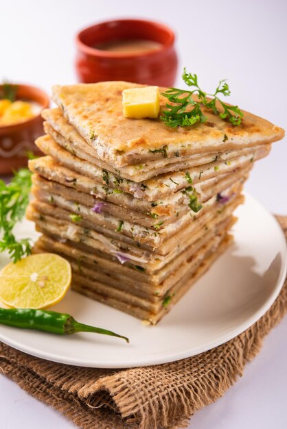 Paneer paratha es un popular pan plano del norte de la India hecho con masa de harina de trigo integral y relleno con paneer sabroso, condimentado y rallado.
