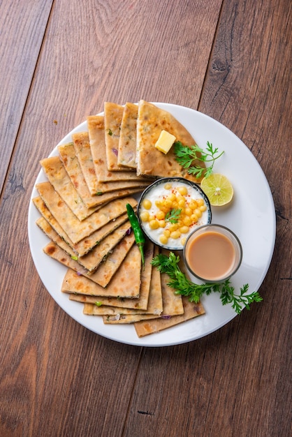 Paneer paratha es un popular pan plano del norte de la India hecho con masa de harina de trigo integral y relleno con paneer sabroso, condimentado y rallado.