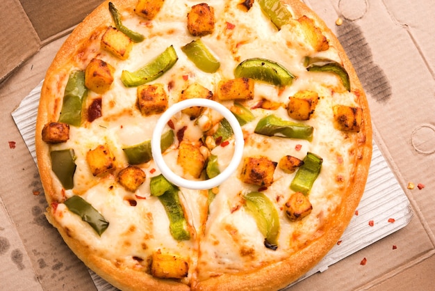 Paneer Pizza ist eine indische Version eines italienischen Gerichts mit Hüttenkäse, serviert auf einem Teller mit weißer Soße. selektiver Fokus