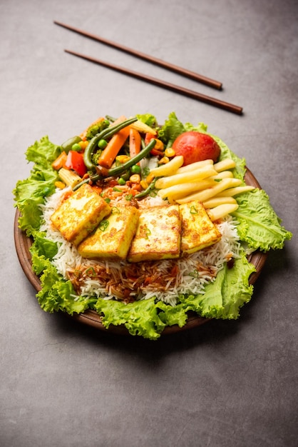 Paneer Sizzler é uma versão indiana com salada de requeijão servida escaldante em prato de pedra quente