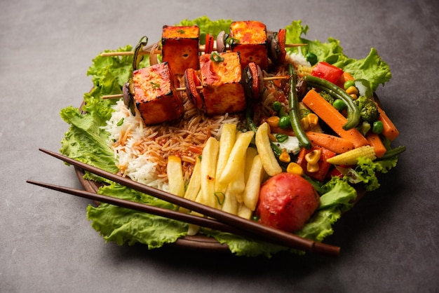 Paneer Sizzler é uma versão indiana com salada de requeijão servida escaldante em prato de pedra quente