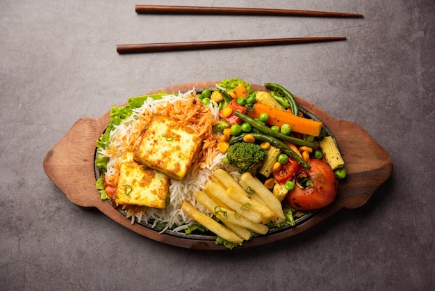 Paneer Sizzler es una versión india con ensalada de requesón servida en un plato de piedra caliente