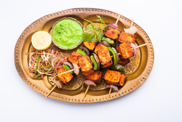 Paneer tikka es un plato indio elaborado con trozos de requesón marinado en especias y asado a la parrilla en un tandoor.