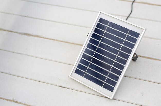 Panel de células solares sobre fondo blanco de madera.