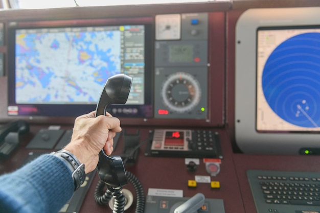 Panel de control de navegación y radio VHF con mano Comunicación por radio en el mar Trabajando en el barco