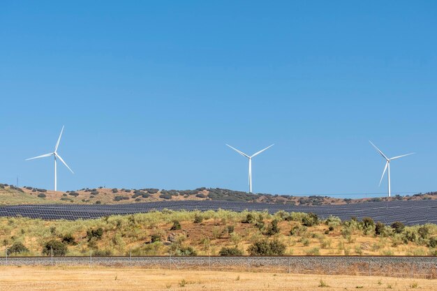 Panel de energía solar, célula fotovoltaica y generador de energía de granja de turbinas eólicas en el paisaje de la naturaleza