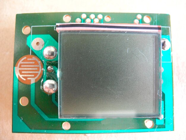 Foto panel lcd en miniatura en la placa base detalle de una placa de circuito impreso electrónico con pantalla montada