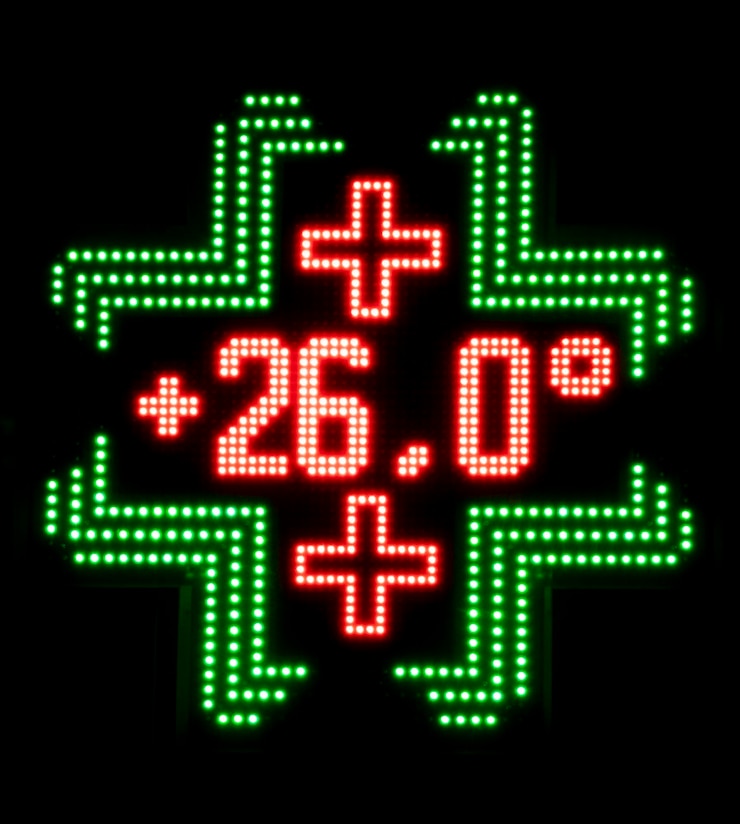 Foto el panel led de farmacia muestra una temperatura de 26 grados centígrados en el fondo negro nocturno