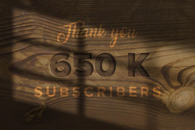 Foto un panel de madera con las palabras gracias 650 k suscriptores en él