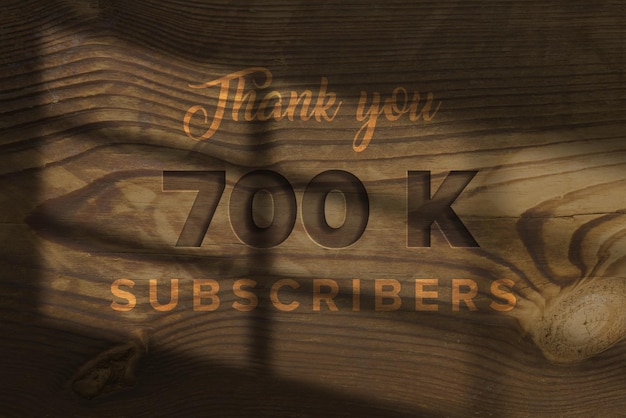 Un panel de madera con las palabras gracias 700 K suscriptores en él