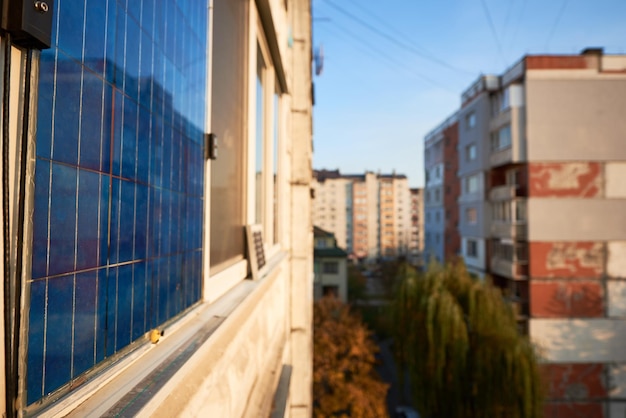 Panel solar en el balcón del edificio de varios pisos de fondo urbano