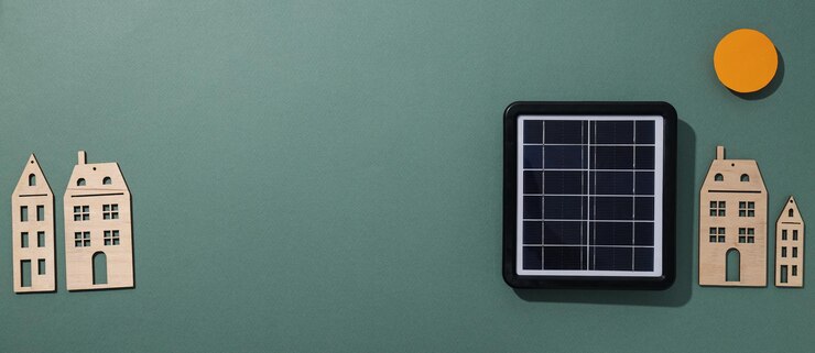 Panel solar y casas de madera sobre fondo verde espacio para texto