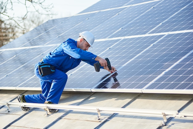 Panel solar de montaje de electricista en el techo de la casa moderna