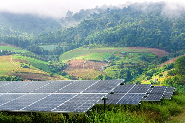 El panel solar en el pequeño pueblo montañoso y la niebla son bellas desde el punto de vista, concepto alternativo de energía verde limpia