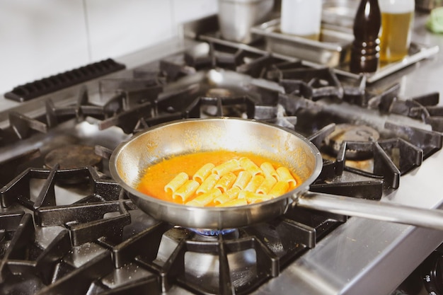 panela com macarrão no fogo fogão cozinhando