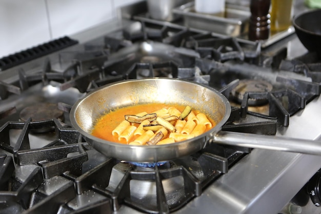 panela com macarrão no fogo fogão cozinhando