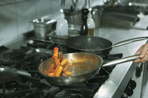 panela com macarrão no fogo fogão cozinhando