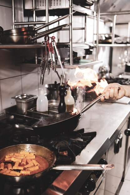 Foto panela com macarrão no fogo fogão cozinhando