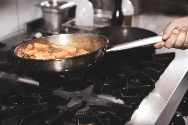 Panela com macarrão no fogo fogão cozinhando